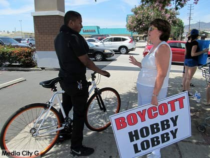 Photo: FLLewis/Media City G -- Protest organizer Cheryl Holt explained the issue against Hobby Lobby to a Ralph Grocery store employee in Burbank July 12, 2014