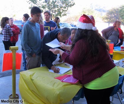 Photo: FLLewis / Media City G -- Volunteers lined up to get information on holiday basket deliveries at Washington Elementary in Burbank December 13, 2014