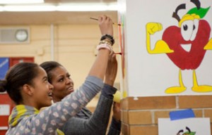 Photo: Samantha Appleton/White House -- First Lady Michelle Obama and daughter Malia paint on a cafeteria wall as part of a service project at Stuart Hobson Middle School in DC  January 17, 2011