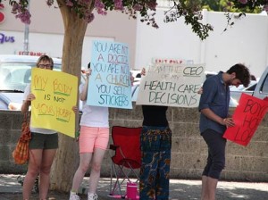 Photo: Greg Reyna Freelance Photog -- Demonstrators waved protest signs at traffic in front of Hobby Lobby in Burbank July 12, 2014