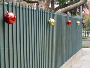 Photo: FLLewis/Media City G -- Large brightly colored Christmas ornaments along with an American flag decorate a fence in the Rancho area of Burbank December 2012