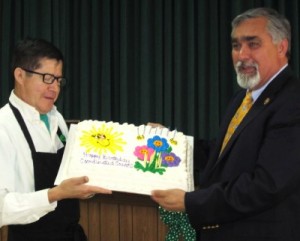 Photo: FLLewis/Media City G -- Burbank Mayor Jess Talamantes helped a dining staff member show off the Burbank Coordinating Council birthday cake at the Little White Chapel in Burbank March 5, 2012