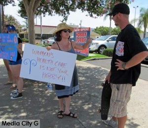 Photo: FLLewis/Media City G --Protester and Burbank resident Tina McDermott explained the Hobby Lobby issue to a skateboarder in Burbank July 12, 2014