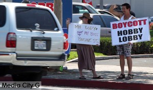 Photo: Greg Reyna/ Freelancer / Media City G --(l-r) Demonstrators Tina McDermott and Chris Kelley held up protest signs in front of Hobby Lobby in Burbank July 26, 2014