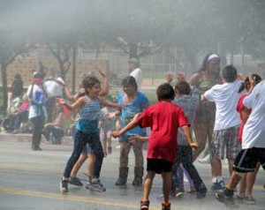 Photo: FLLewis/Media City G -- Young spectators played and danced in the water spray of the Bob Hope Airport fire truck during Burbank on Parade April 6, 2013