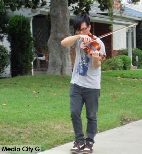 Photo: FLLewis/ Media City G -- A young actor played a violin on a morning stroll on a Burbank street  August 8, 2014