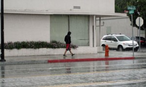 Photo: FLLewis/Media City G -- A man walks in the rain on West Olive Avenue near North Lomita Street in Burbank October 11, 2012