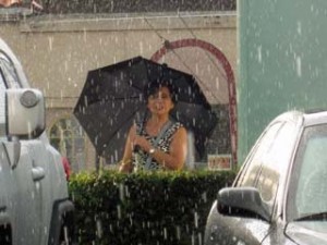 Photo: FLLewis/Media City G -- A woman under an umbrella watched the rain fall at a bus stop on East Alameda Avenue near San Fernando Boulevard in Burbank August 30, 2012